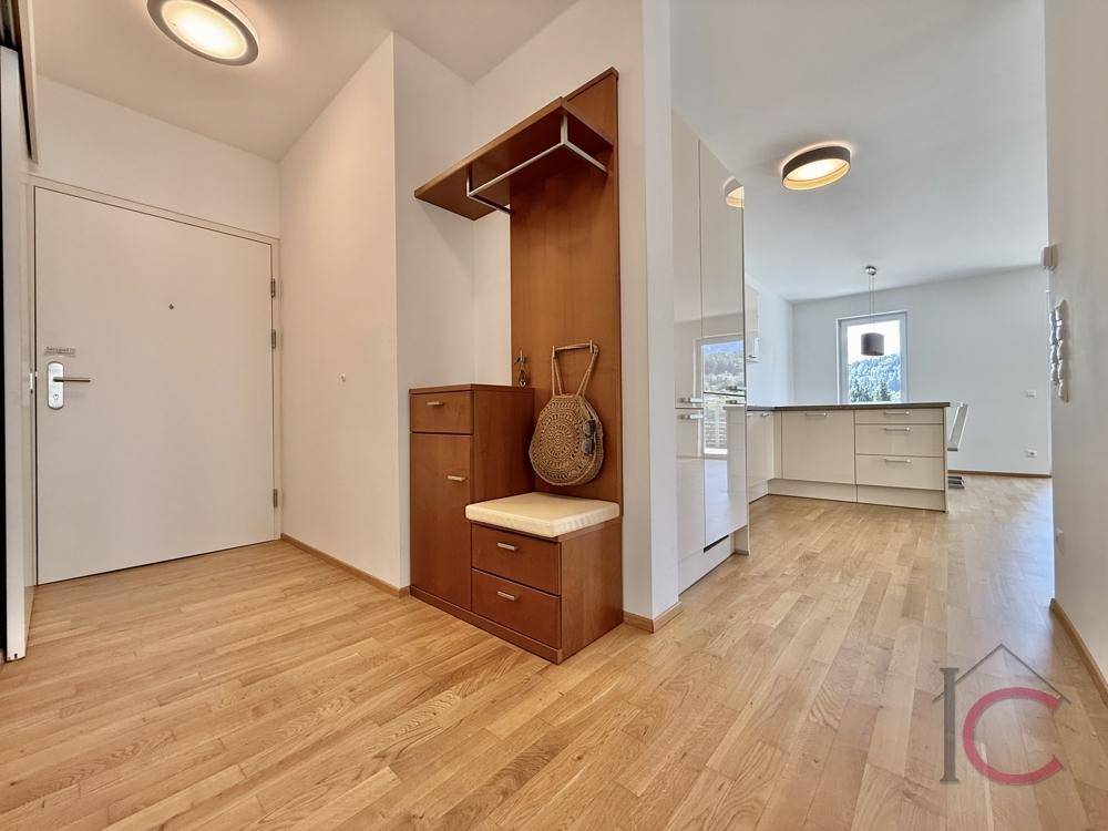Eingangsbereich mit Garderobe und Blick in den offenen Wohn- und Küchenbereich.