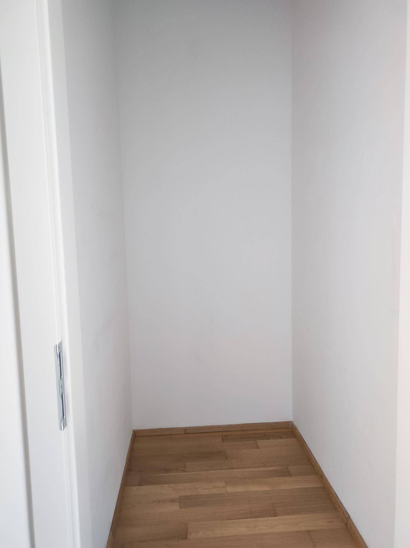 Praktischer Abstellraum mit Holzboden und weißen Wänden, ideal für zusätzlichen Stauraum.
