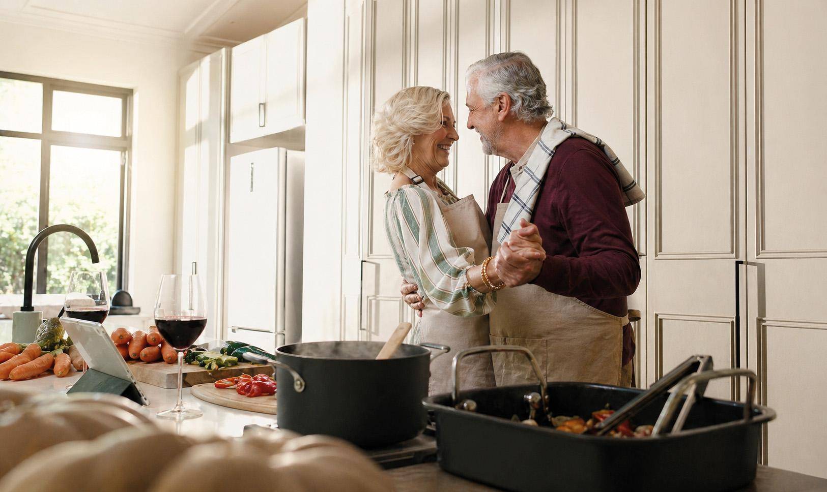 Helle Küche mit modernen Schränken, Arbeitsplatte und einem Paar beim Kochen.