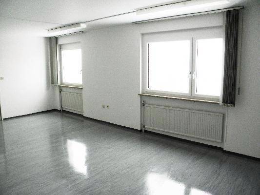 Helles Büro mit zwei großen Fenstern und Heizkörpern, ideal für eine produktive Arbeitsumgebung.