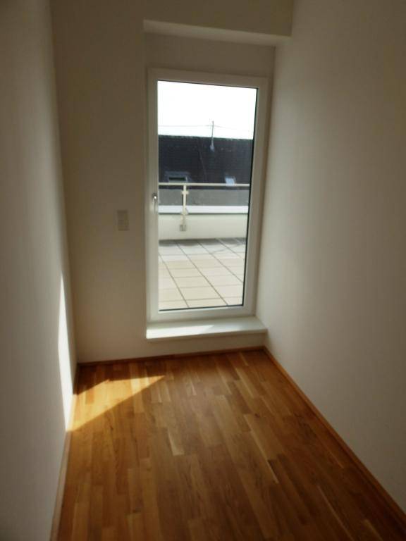 Kleiner, heller Raum mit direktem Zugang zur Terrasse und Parkettboden.
