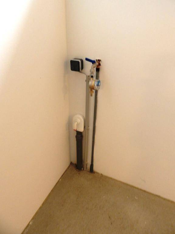 Ecke eines Abstellraums mit sichtbaren Wasserleitungen und Anschlüssen.