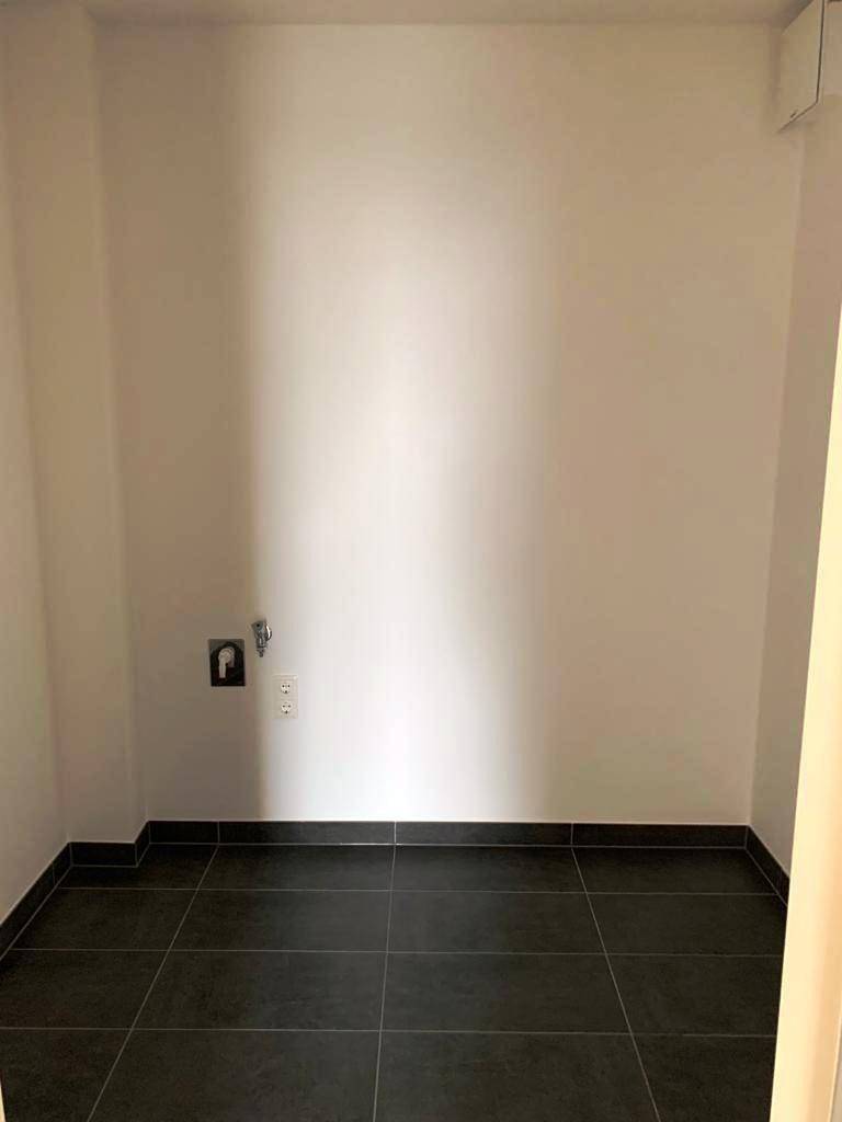 Leerer Raum mit Fliesenboden und Anschlüssen, ideal als Abstell- oder Hauswirtschaftsraum.