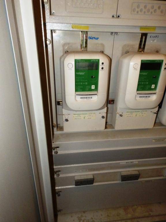 Ein Schaltschrank mit mehreren digitalen Stromzählern und Sicherungen in einem Technikraum.