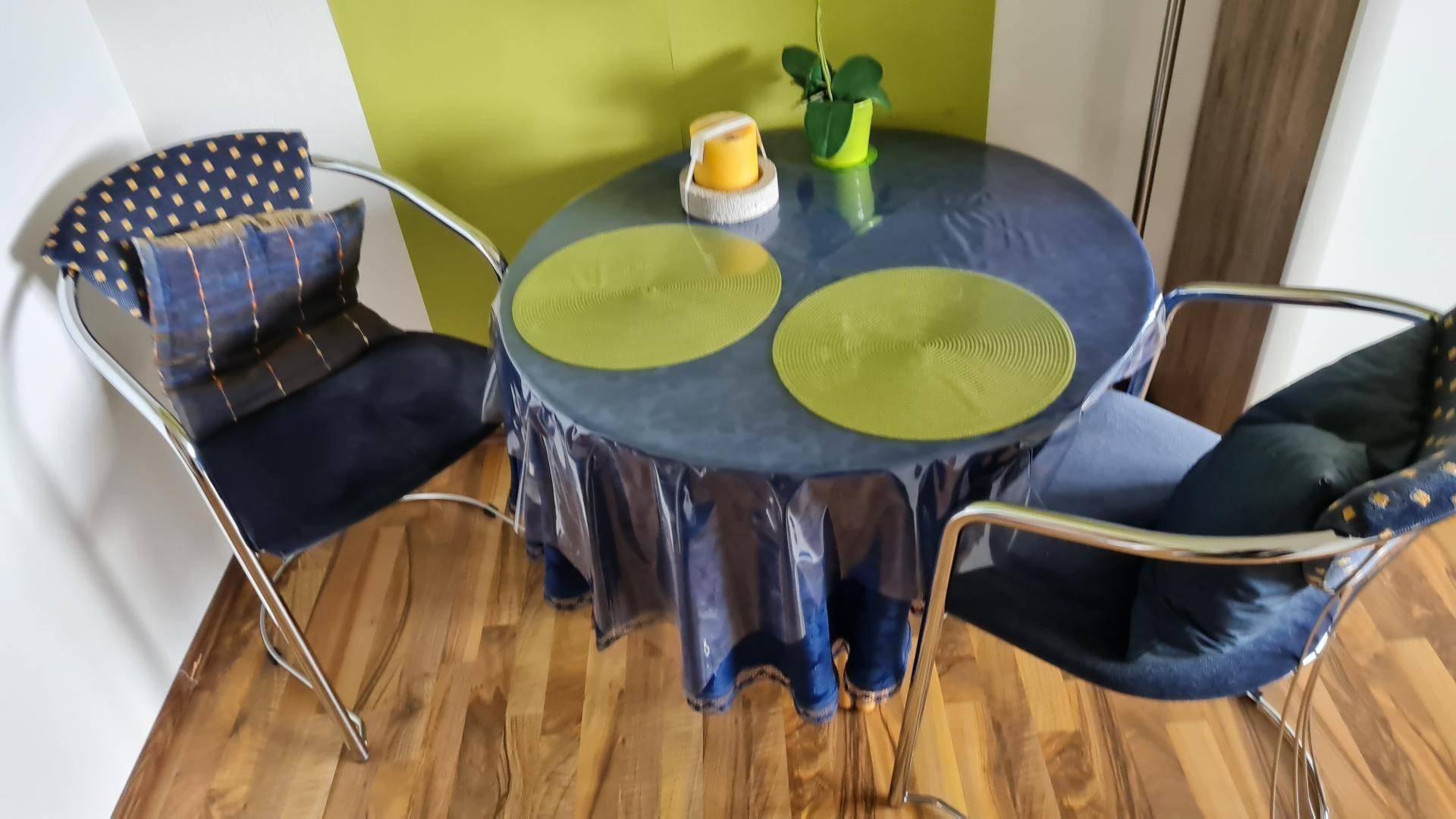 Kleiner Essbereich mit rundem Tisch und zwei Stühlen auf Laminatboden.