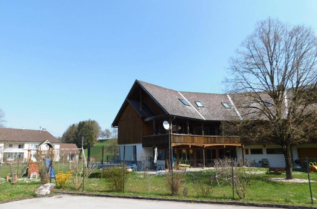 Panoramablick auf das Anwesen von der Straße, mit mehreren Gebäudeteilen und weitläufigem Grundstück.