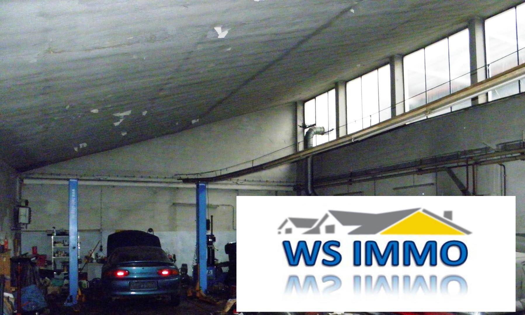 Werkstatt mit Hebebühne, Werkzeugen und hohen Fenstern, ideal für Reparaturen.