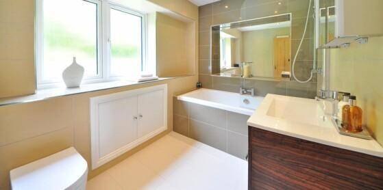 Modernes Badezimmer mit Badewanne, großem Spiegel und Fenster für Tageslicht.