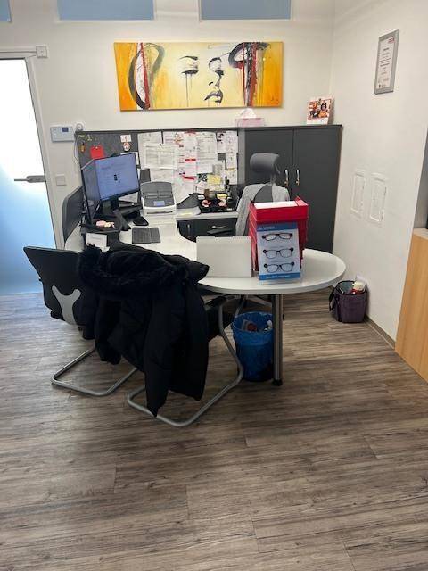 Modernes Büro mit Schreibtisch, Computer und Kunstwerk an der Wand, ausgestattet für den Arbeitsalltag.