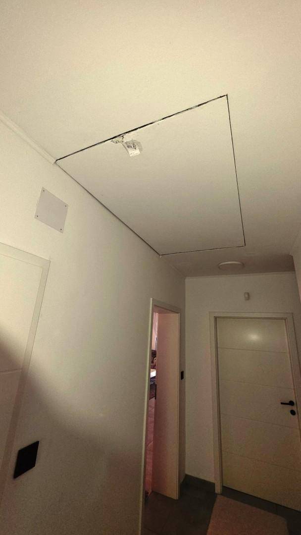 Decke im Flur mit Zugangsklappe zum Dachboden oder Technikbereich.