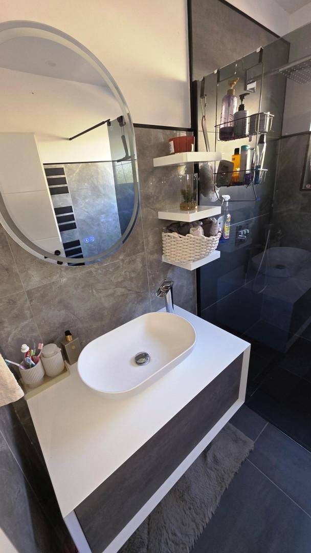 Detailansicht des modernen Waschbeckens und Spiegels im stilvollen Badezimmer.