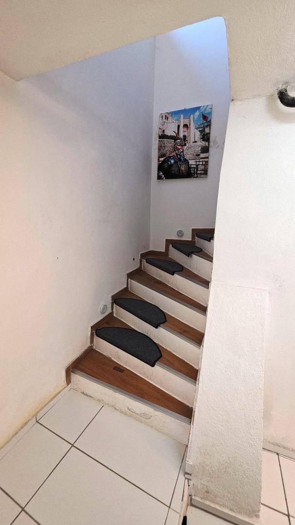 Treppenaufgang mit Holzstufen und Teppichläufern, der die Etagen verbindet.