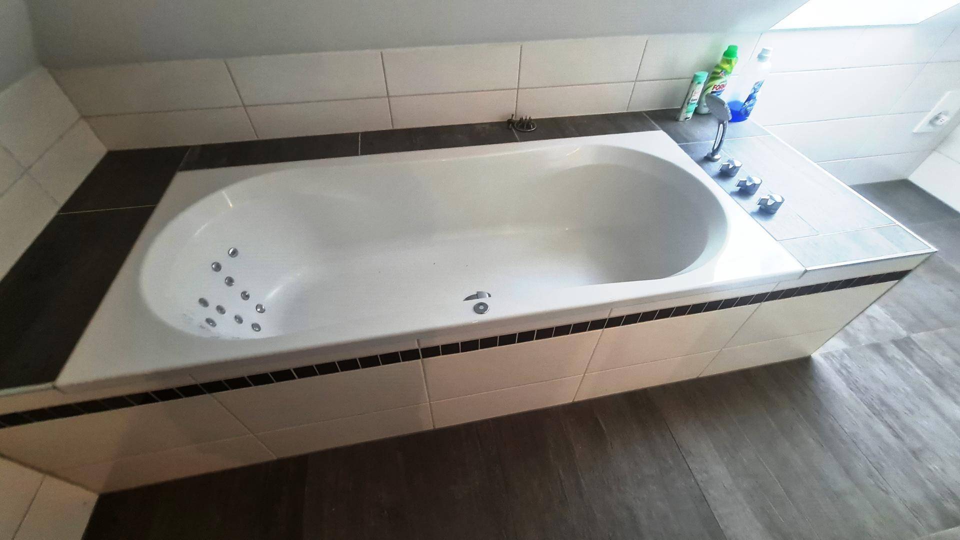 Eingebaute Badewanne mit Whirlpool-Funktion und Fliesenverkleidung für entspannende Momente.
