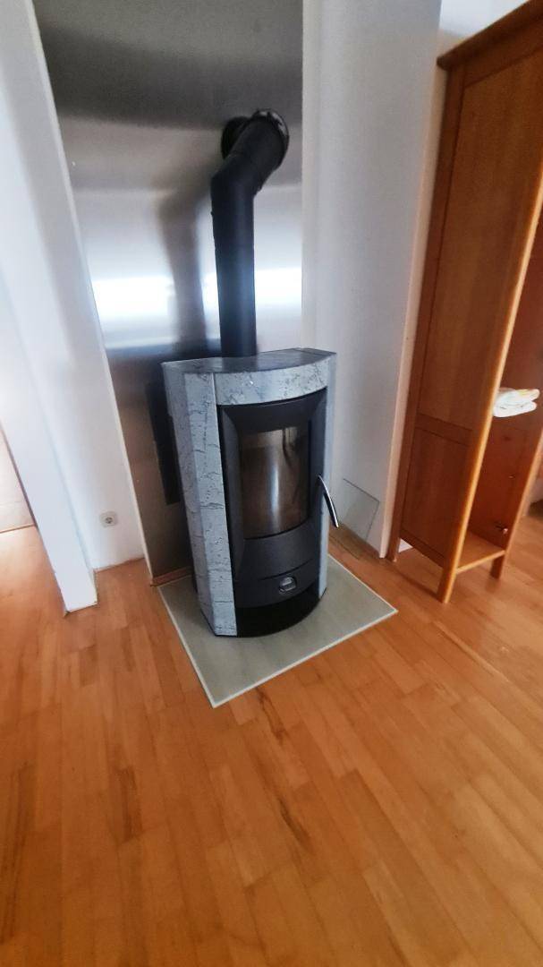 Moderner Kaminofen in einem Wohnraum mit Holzboden, der für Gemütlichkeit sorgt.