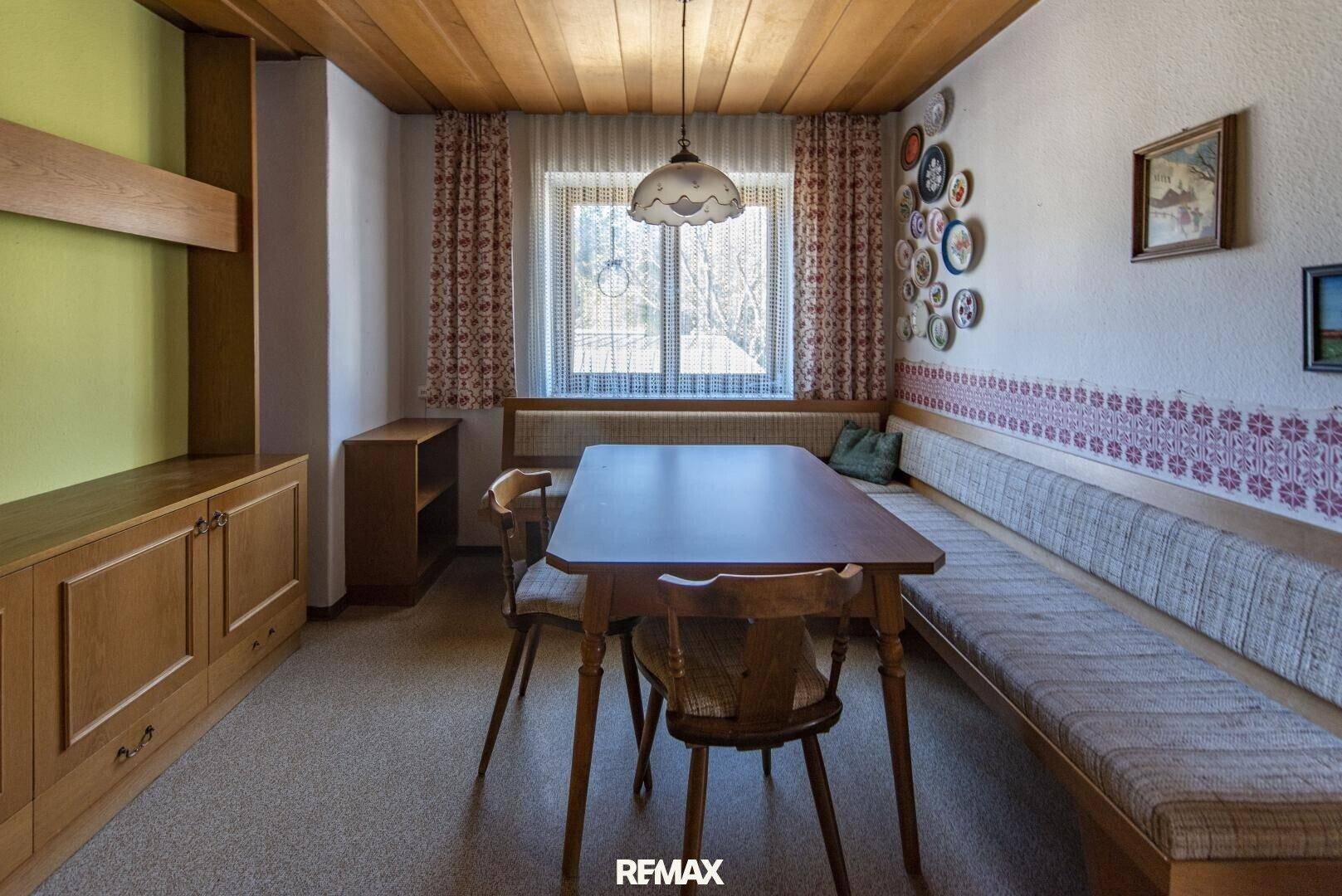 Esszimmer mit Holztisch, Eckbank und traditioneller Dekoration, ideal für gemütliche Mahlzeiten.