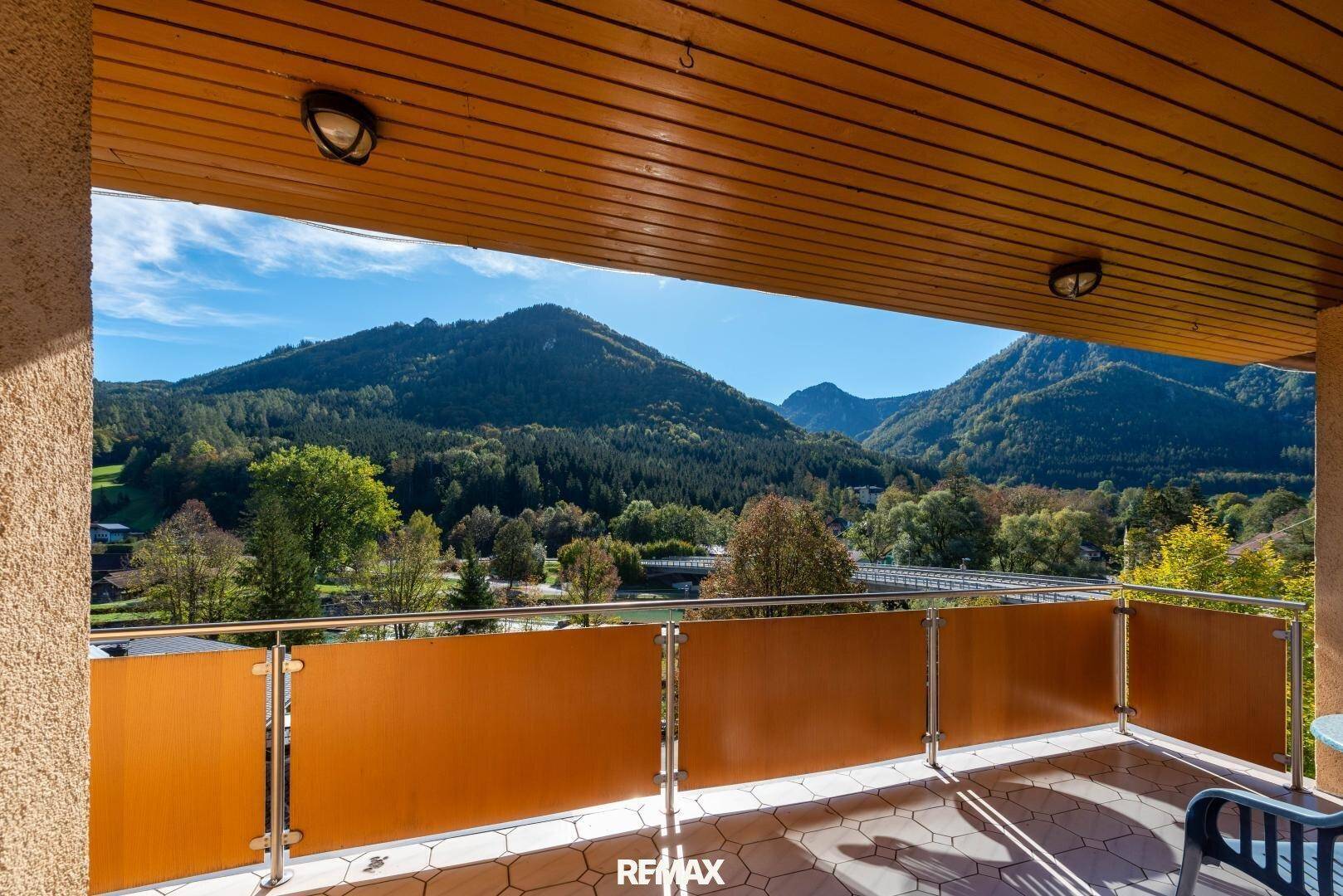 Geräumiger Balkon mit Fliesenboden und einer atemberaubenden Aussicht auf die umliegenden Berge und Wälder.