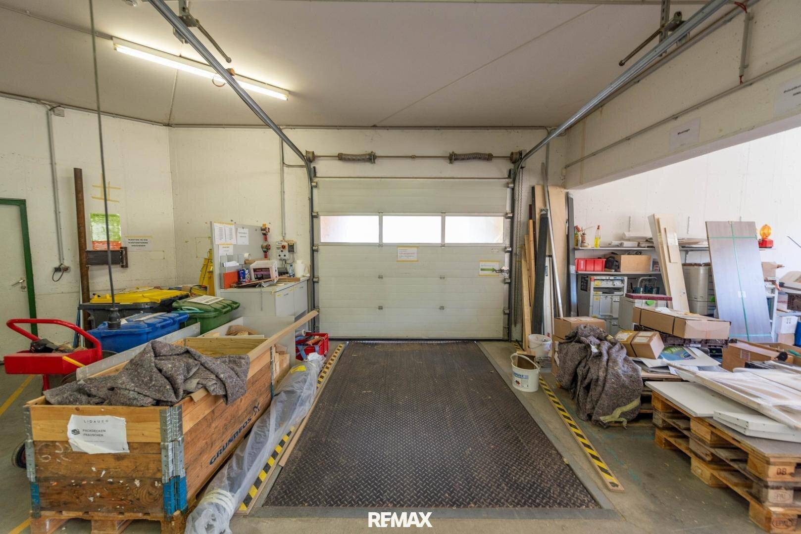 Ladebereich innerhalb einer Lagerhalle mit einer großen Rolltür und einer Rampe.