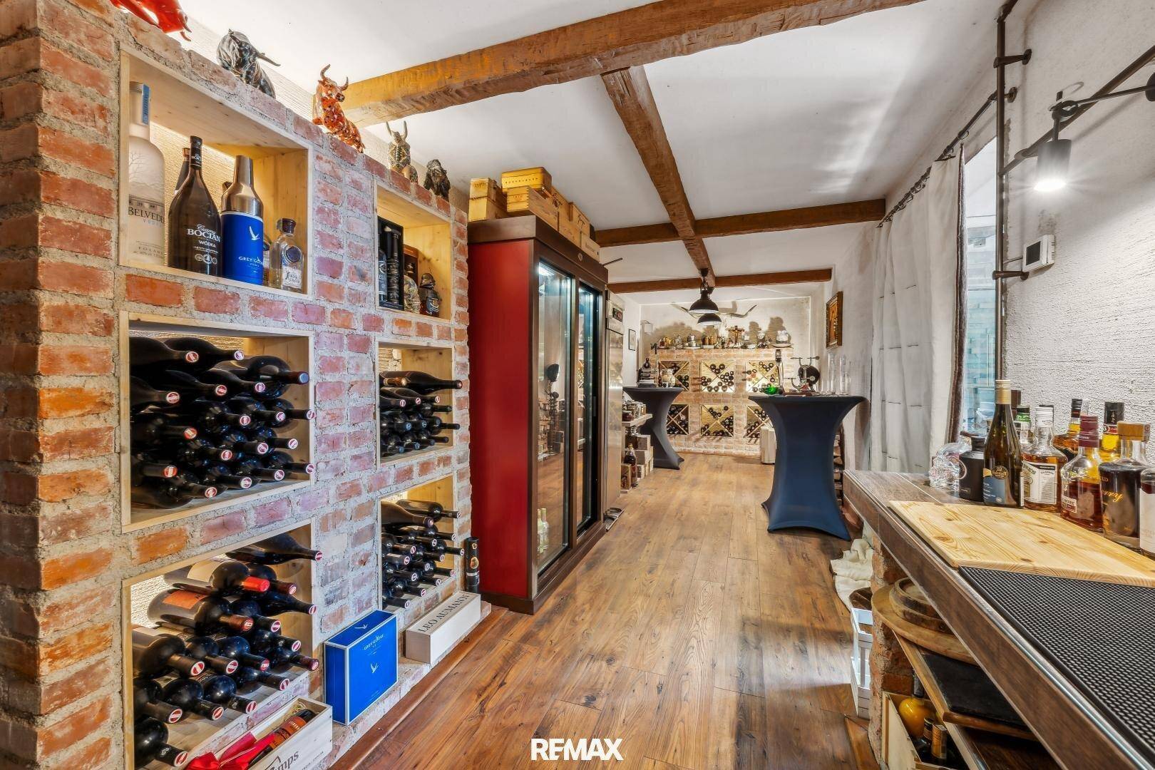 Rustikaler Weinkeller mit Ziegelregalen, Holzbalken und einer kleinen Bar für Verkostungen.