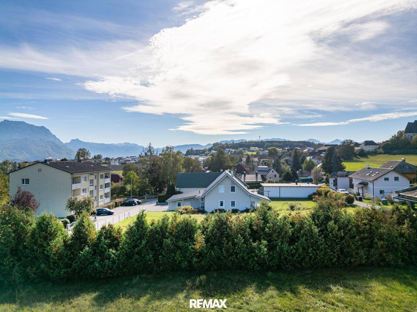 Weitläufige Ansicht einer Wohnsiedlung mit Bergpanorama unter blauem Himmel.
