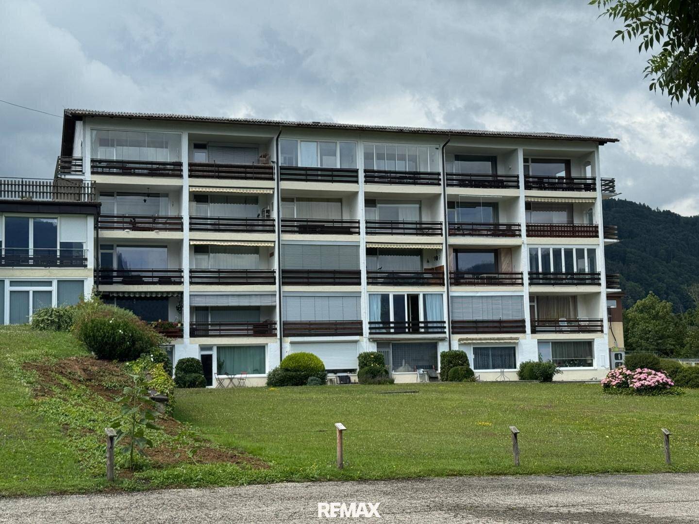 Mehrstöckiges Apartmentgebäude mit zahlreichen Balkonen und Grünflächen im Vordergrund.