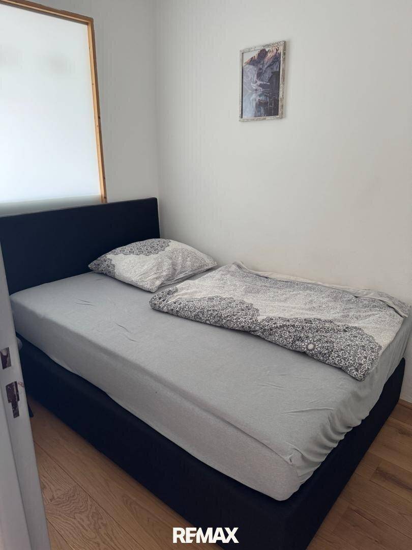 Gemütliches Schlafzimmer mit Einzelbett und Holzboden, ideal als Gästezimmer.