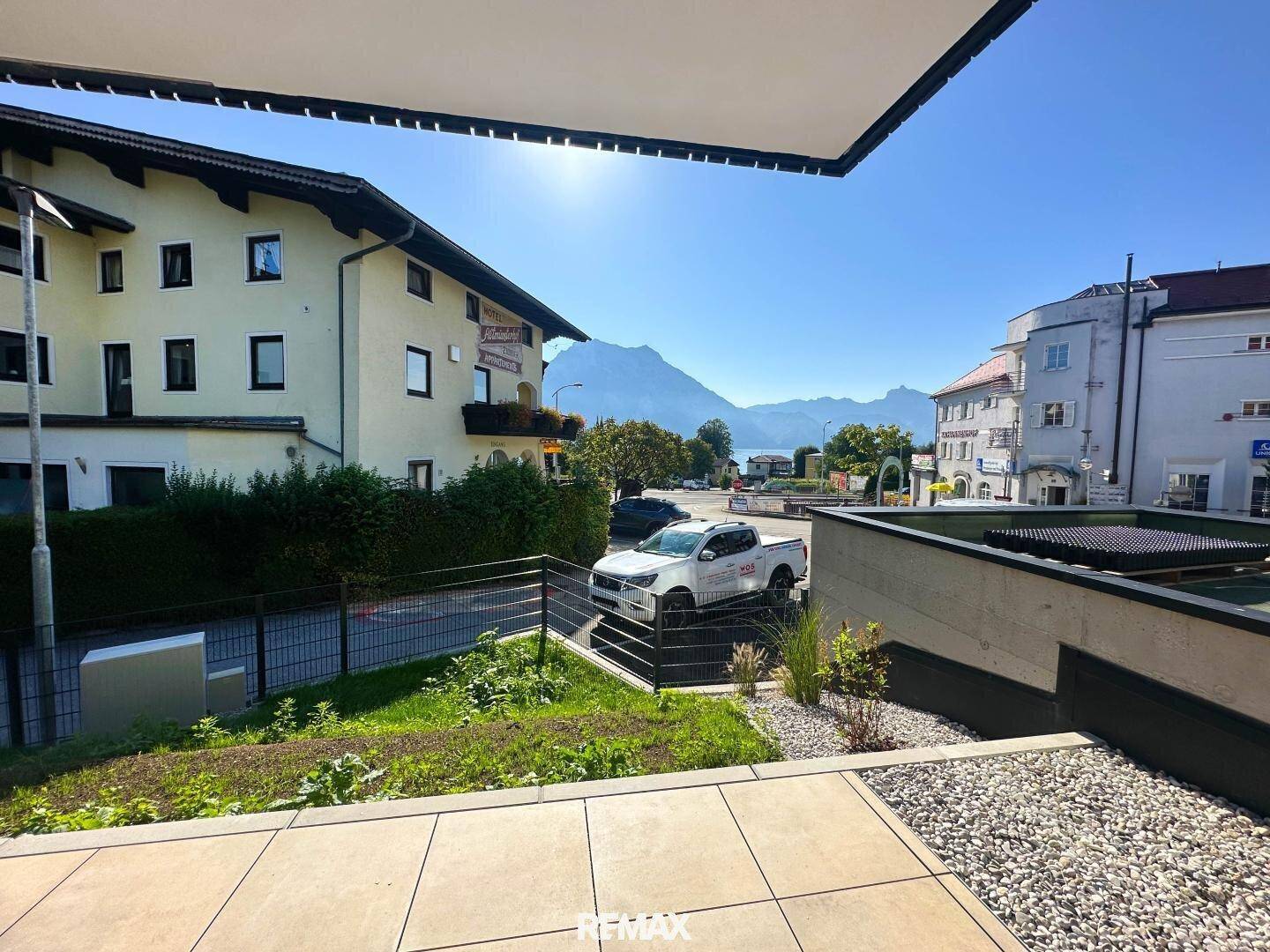 Sonniger Terrassenbereich mit Blick auf den See und die umliegenden Berge.