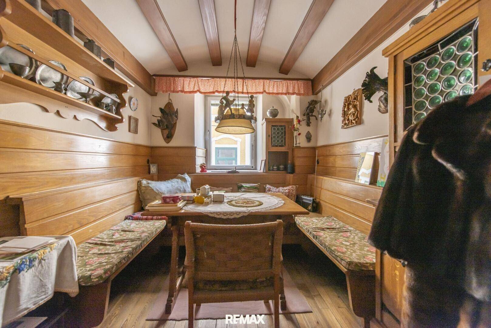 Traditioneller Essbereich mit Holztäfelung, eingebauten Bänken und rustikalen Dekorationselementen.