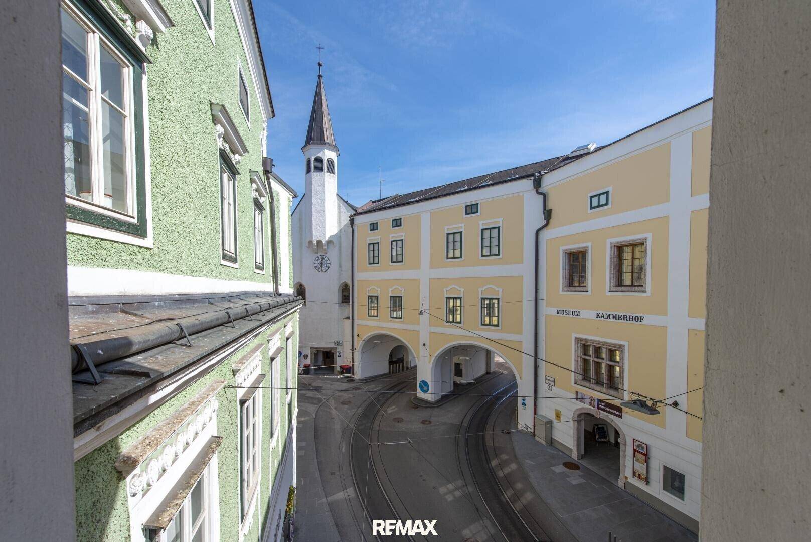 Blick aus einem Fenster auf einen historischen Innenhof mit Kopfsteinpflaster und angrenzenden Gebäuden.