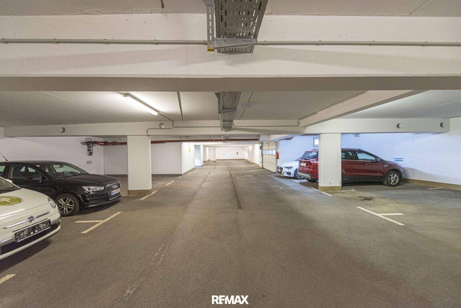 Geräumige Tiefgarage mit zahlreichen Stellplätzen, Betonpfeilern und guter Beleuchtung.