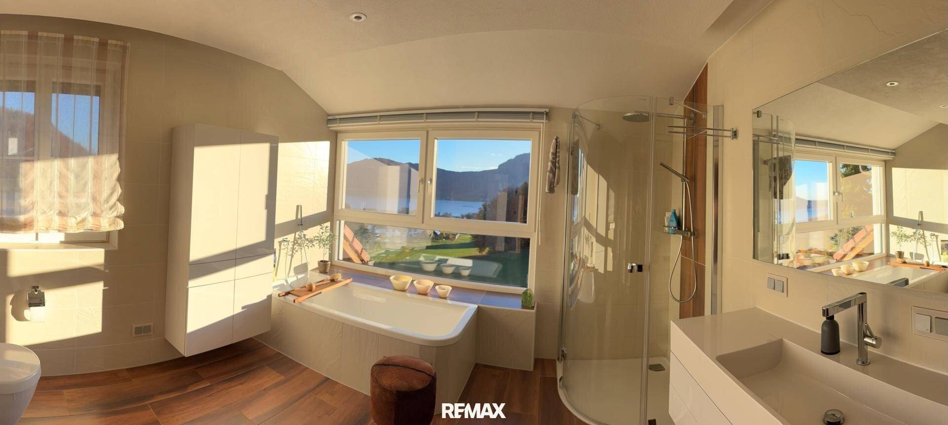 Modernes Badezimmer mit Badewanne, begehbarer Dusche und Doppelwaschbecken mit Seeblick.