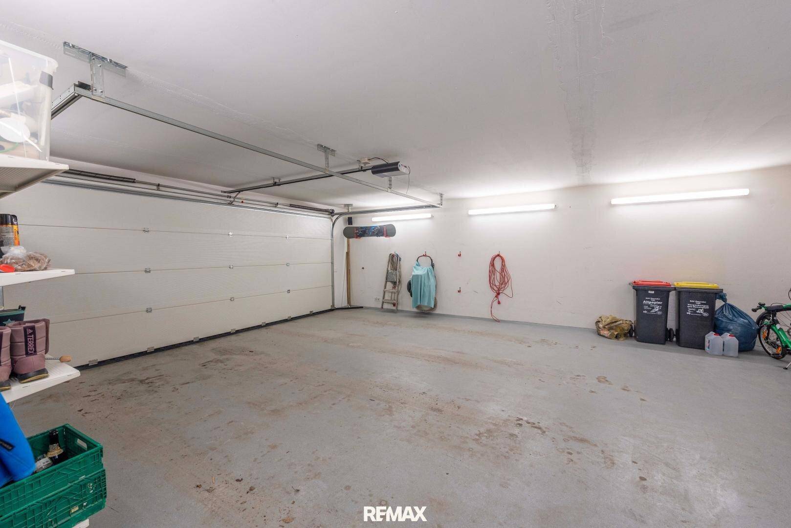 Geräumige Garage mit großem Tor und ausreichend Platz für Fahrzeuge und Lagerung.