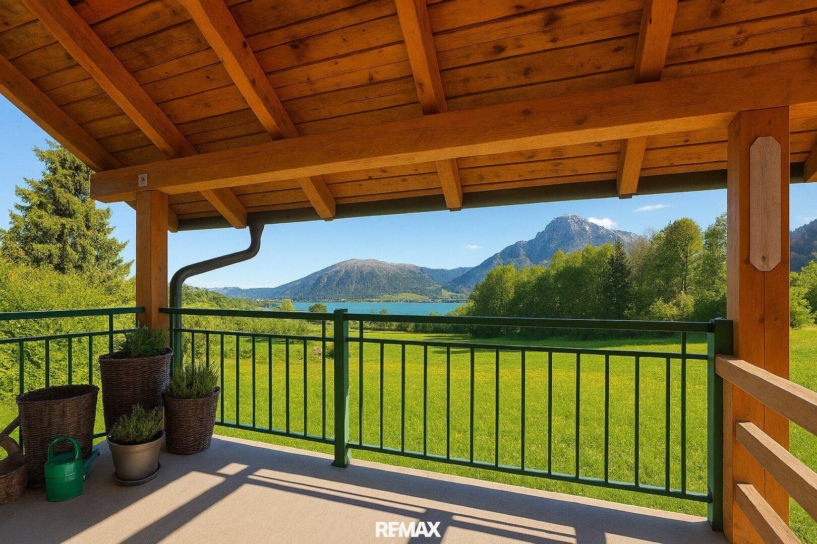 Geräumiger Balkon mit Holzdach und atemberaubendem Blick auf den See und die Berge.
