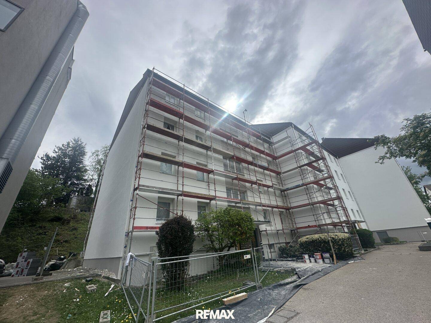 Mehrstöckiges Gebäude in Bauphase, vollständig mit Gerüsten für Renovierungsarbeiten bedeckt.