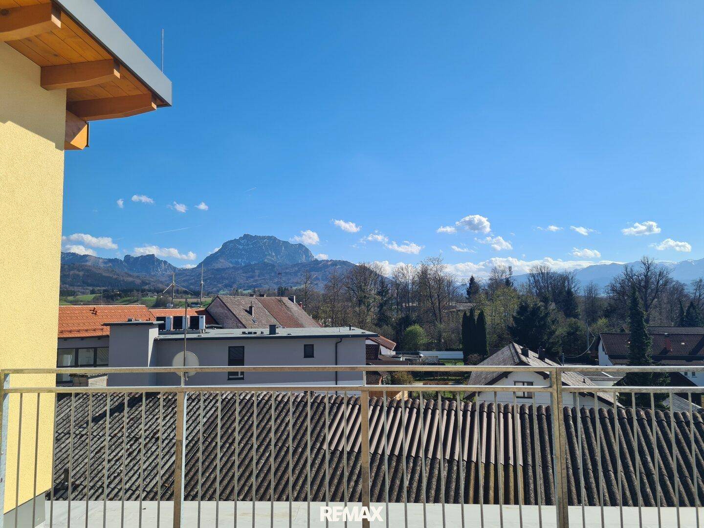 Panoramablick von der Terrasse über Dächer und die beeindruckende Berglandschaft in der Ferne.