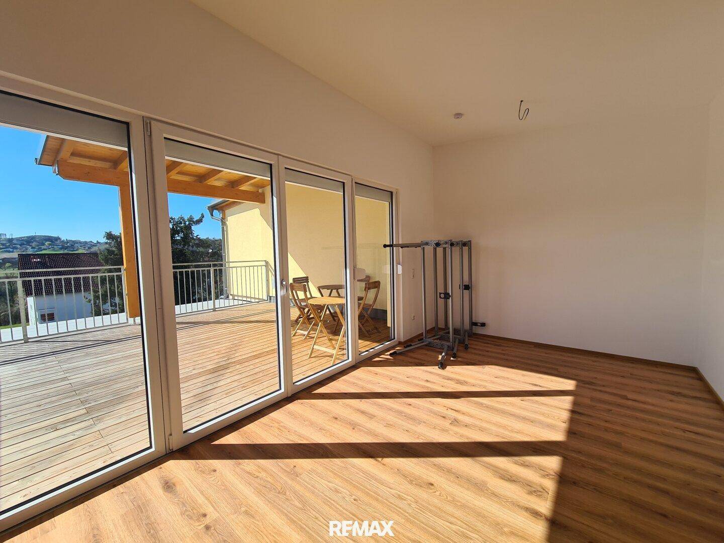 Geräumiger Wohnbereich mit viel Tageslicht durch die großen Fensterfronten und direktem Terrassenzugang.