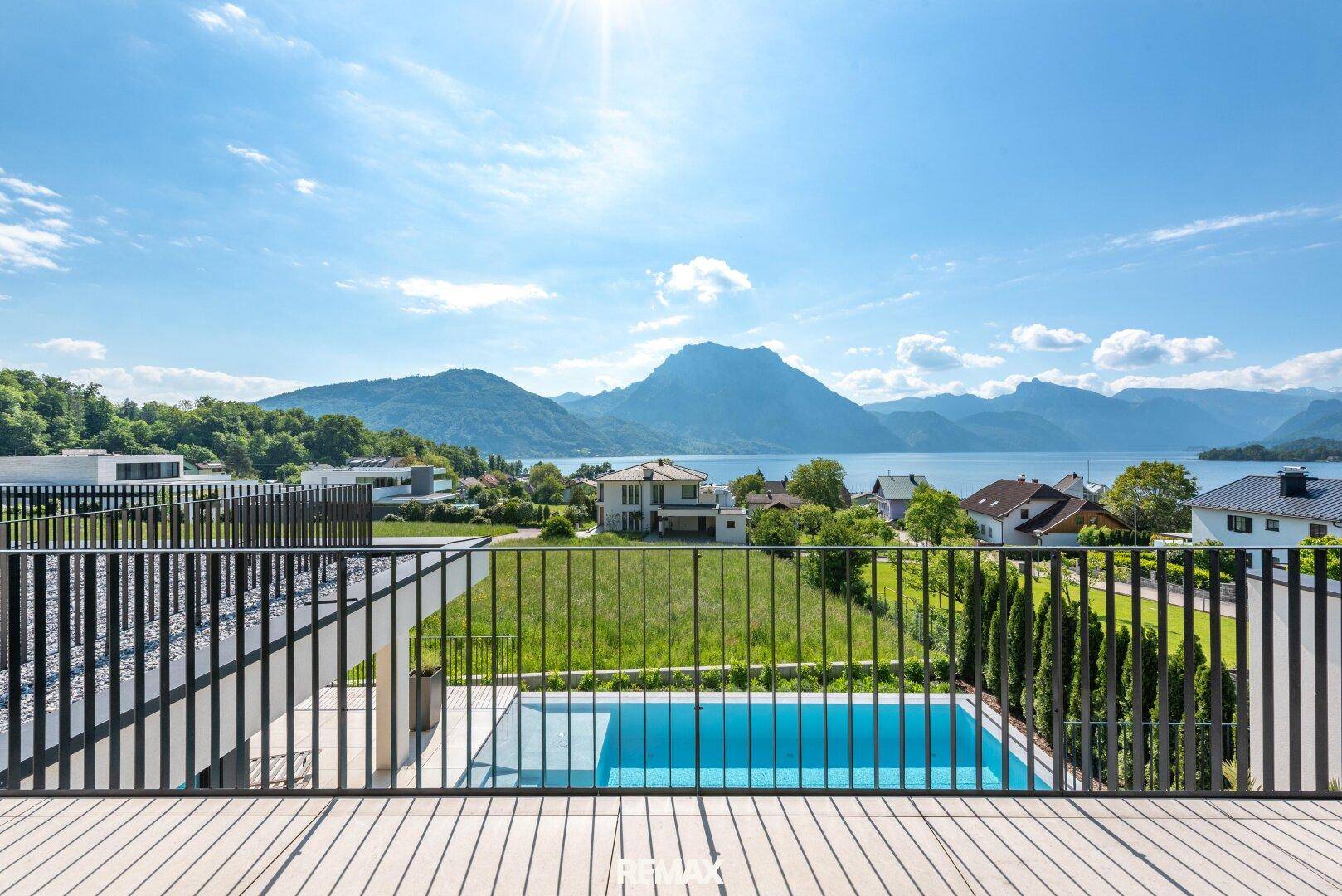 Große Terrasse mit Pool und atemberaubendem Blick auf den See und die umliegenden Berge.