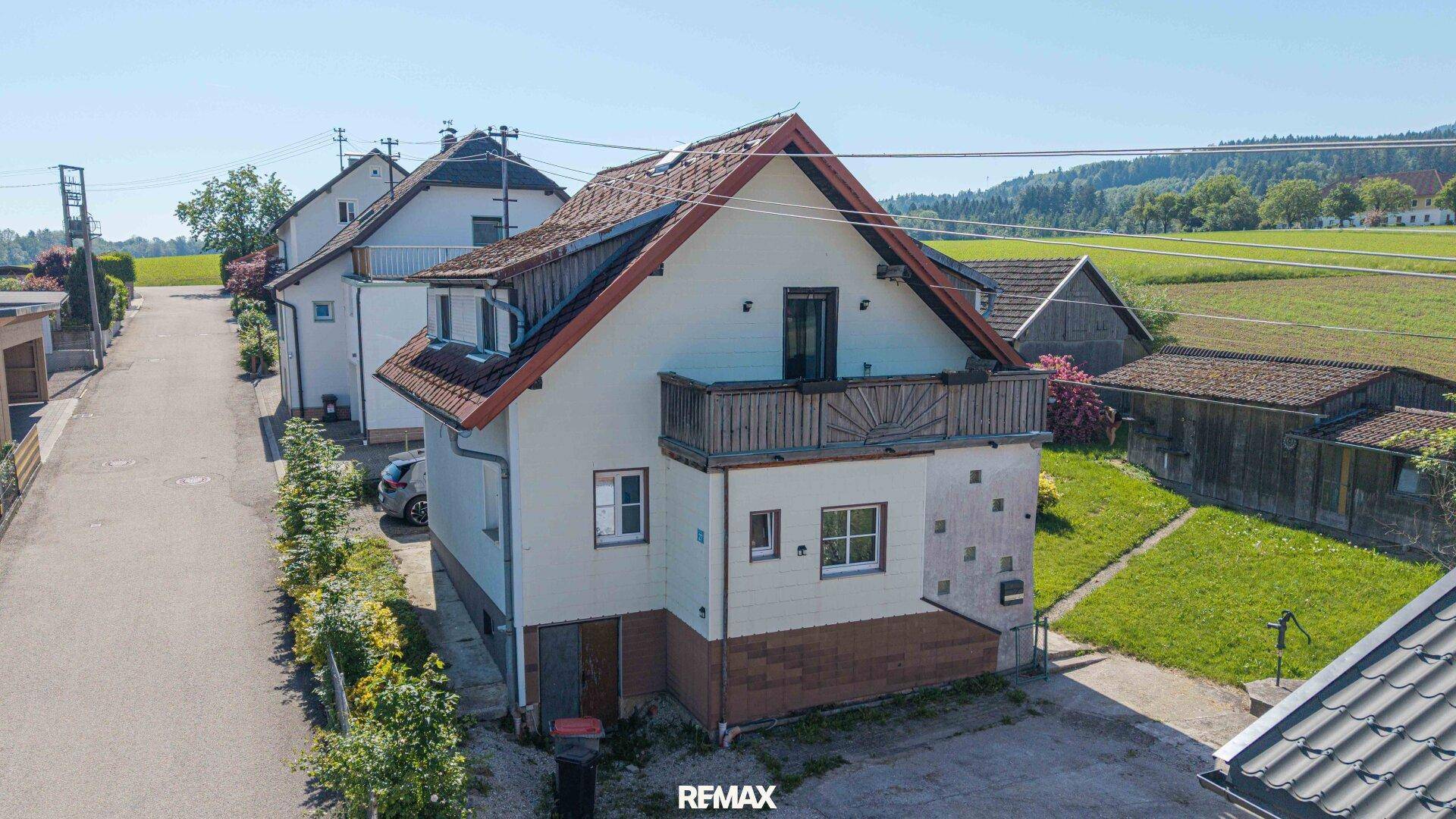 Luftaufnahme des Hauses mit Balkon und ländlicher Umgebung unter klarem Himmel.