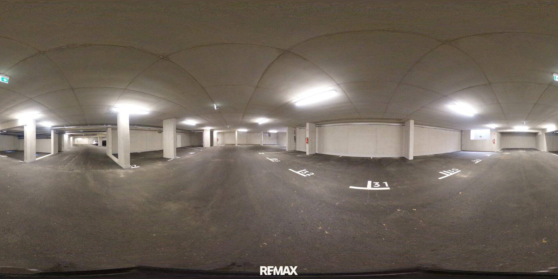Helle Tiefgarage mit markierten Parkplätzen, Betonstützen und guter Beleuchtung.