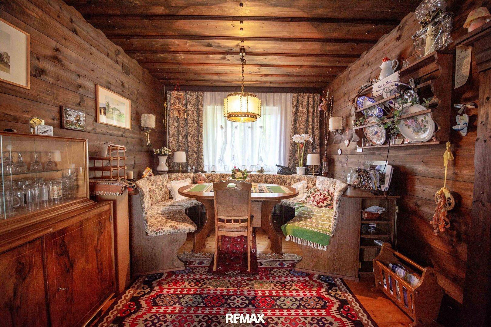 Gemütlicher Essbereich im alpinen Stil mit Holztäfelung, Eckbank und traditionellem Teppich.