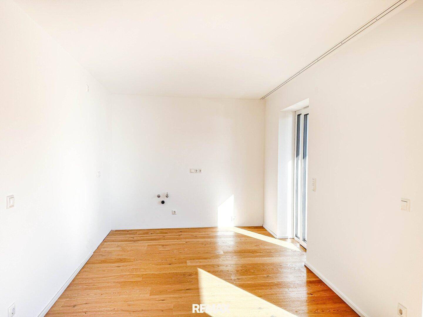 Heller Raum mit Holzboden und Wandanschlüssen, ideal als Hauswirtschaftsraum.