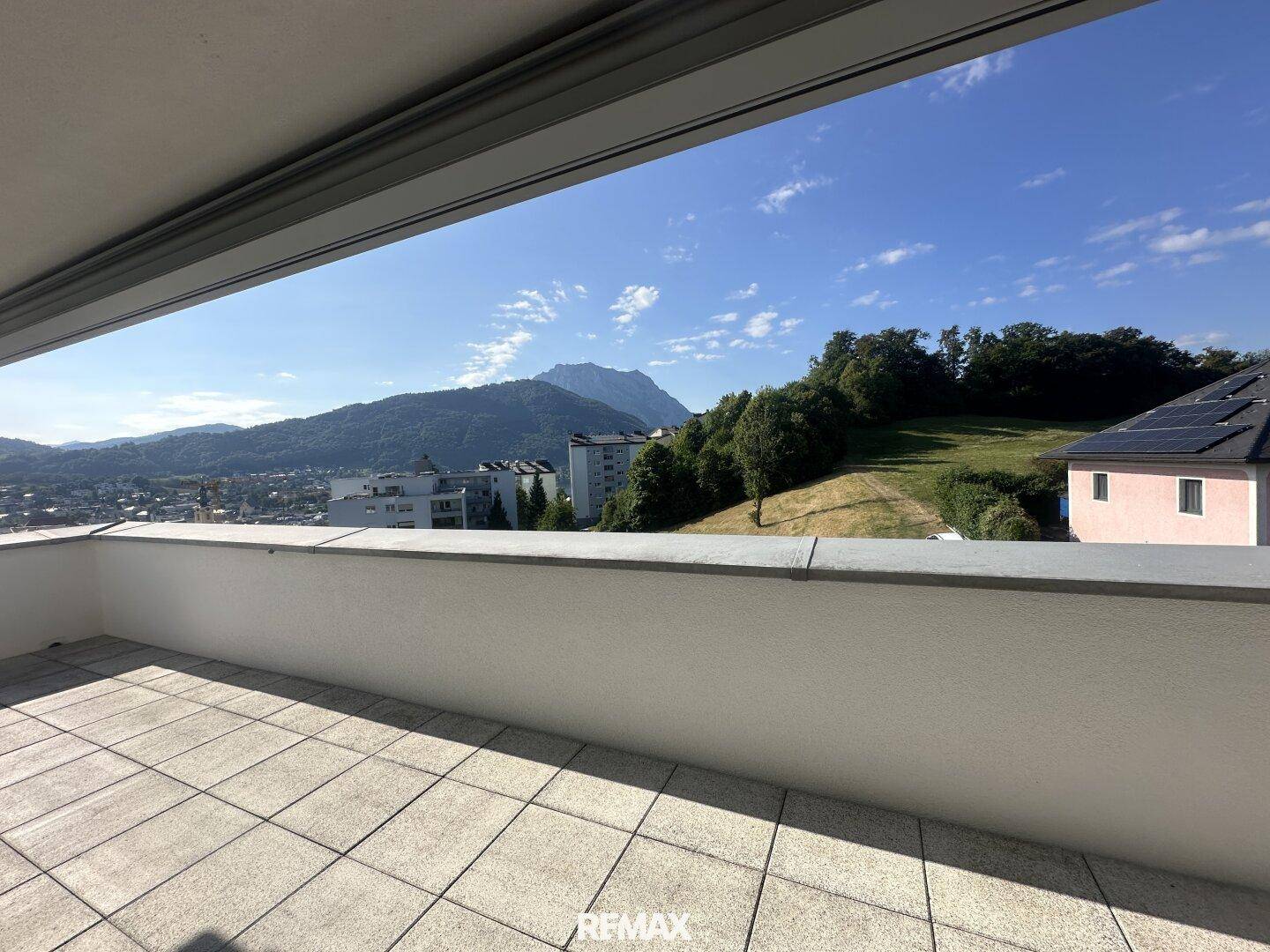 Geräumige Terrasse mit Fliesenboden und weitem Blick auf die Berge und die Umgebung.