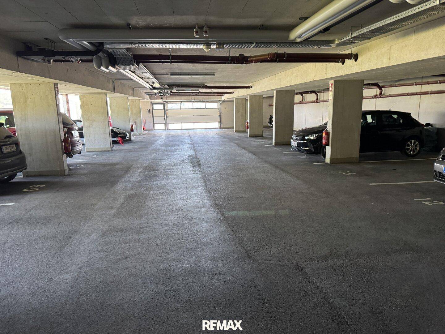 Tiefgarage mit mehreren Stellplätzen und Betonpfeilern.