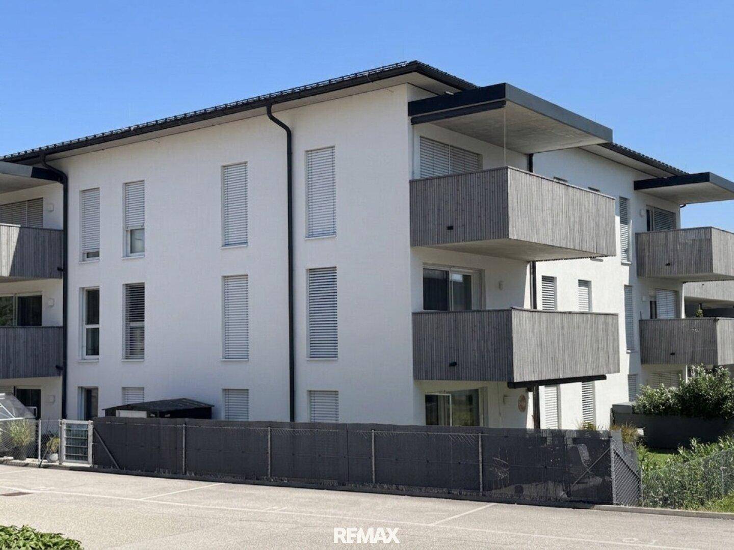 Fassade eines modernen Mehrfamilienhauses mit Holzverkleidung an den Balkonen.