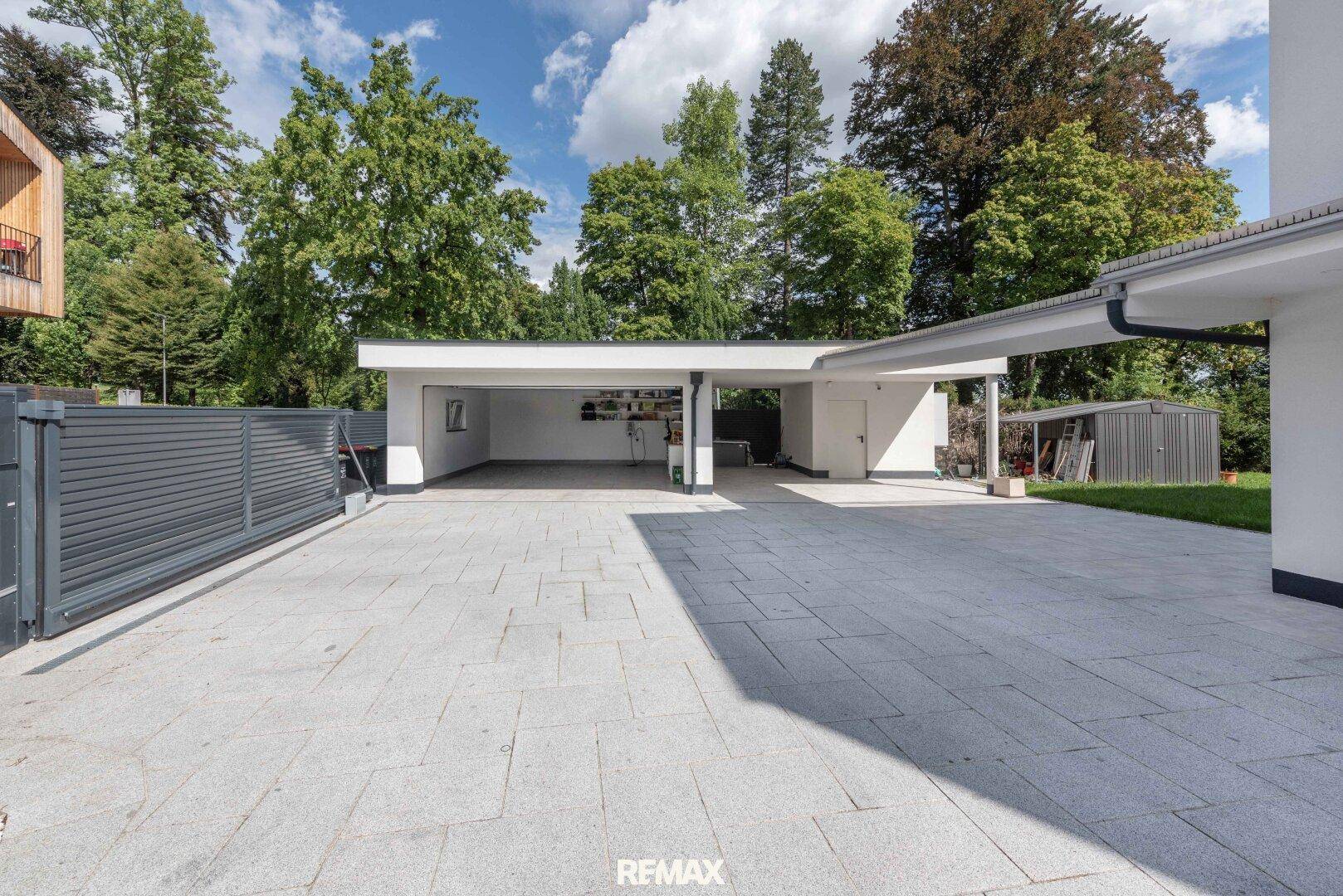 Geräumiger gepflasterter Vorplatz mit Doppelgarage und zusätzlichem Carport.