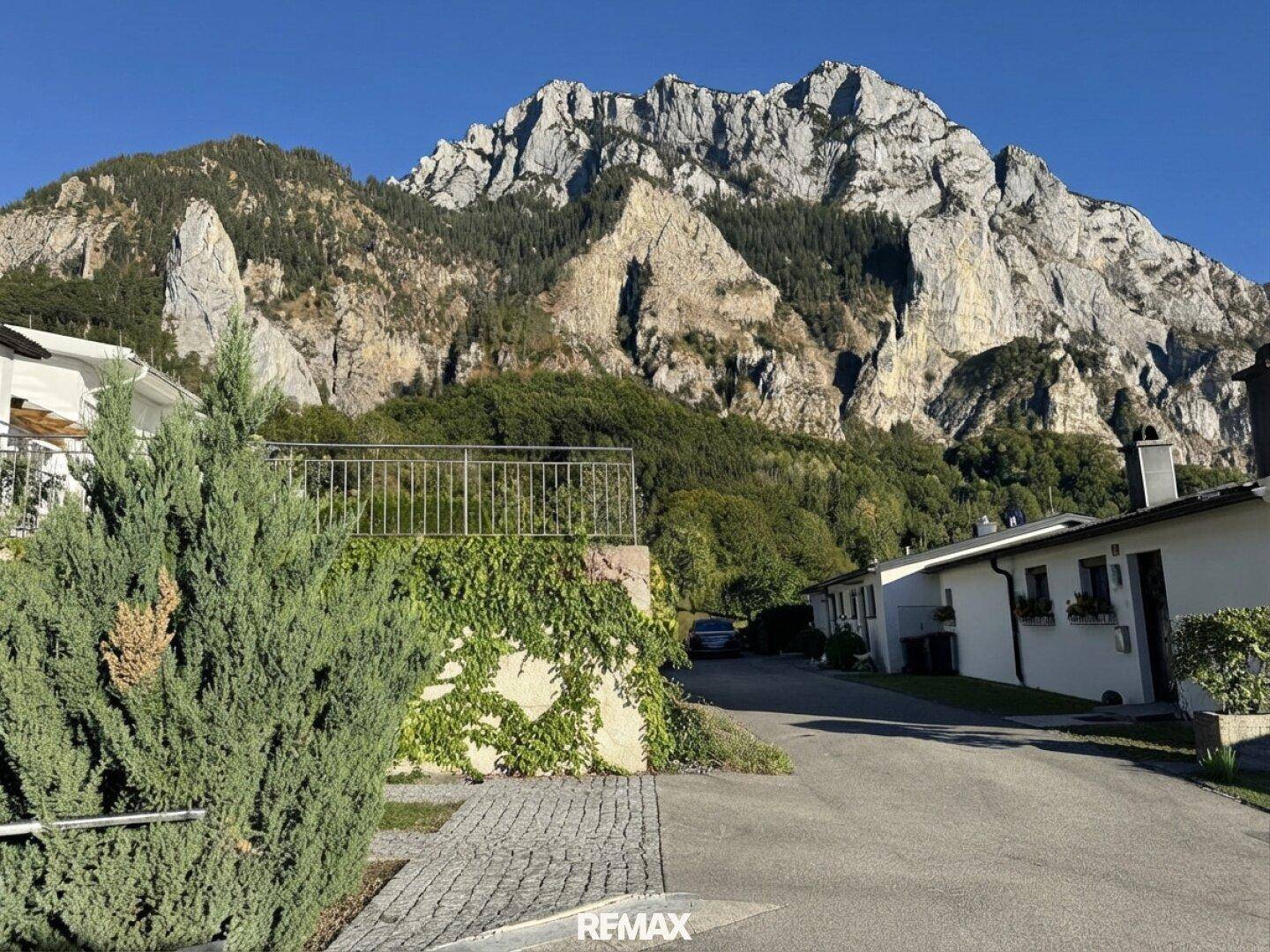 Ruhige Wohngegend mit Blick auf eine beeindruckende Felswand und grüne Vegetation.