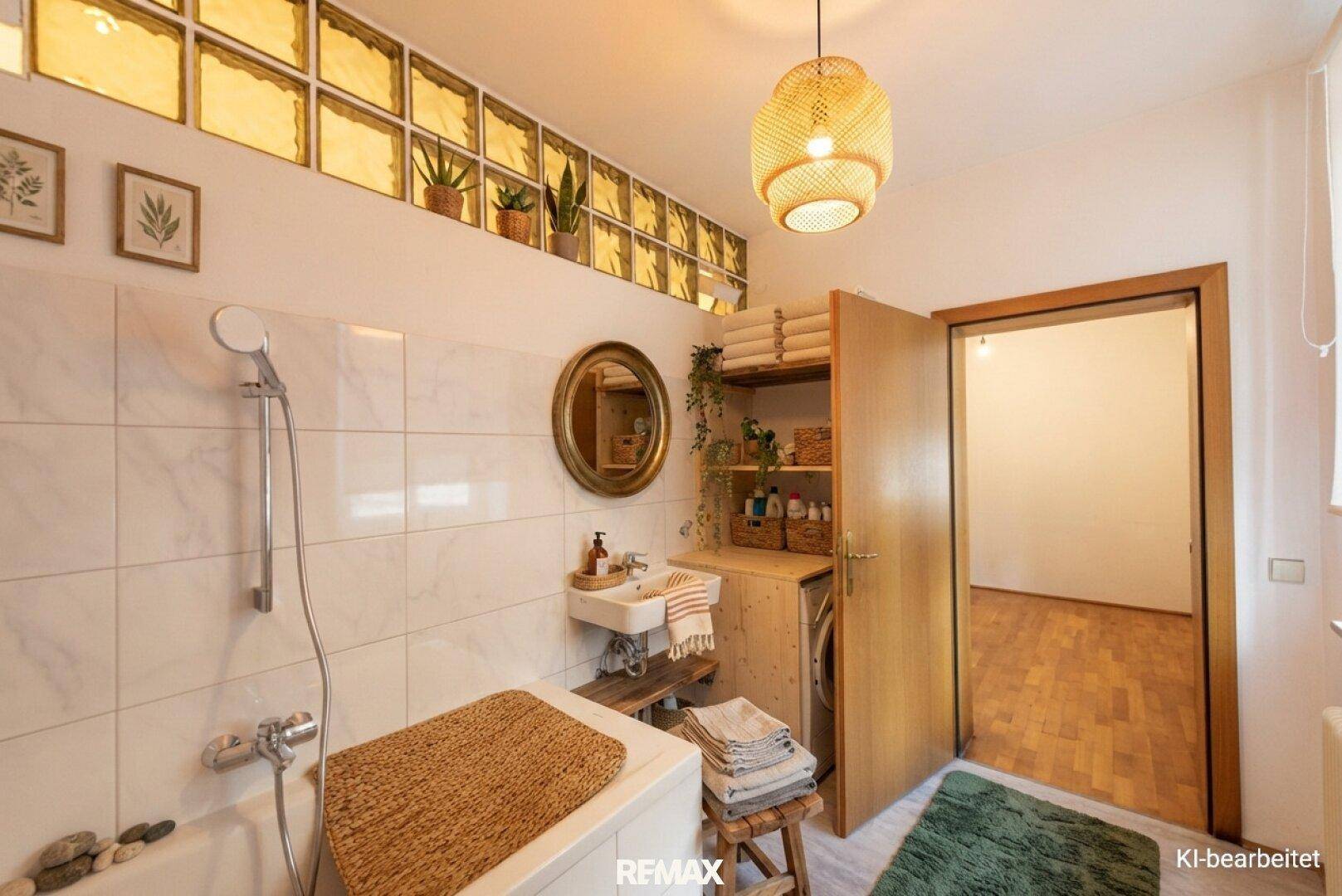 Funktionales Badezimmer mit Dusche, Waschmaschine und dekorativen Glasbausteinen.