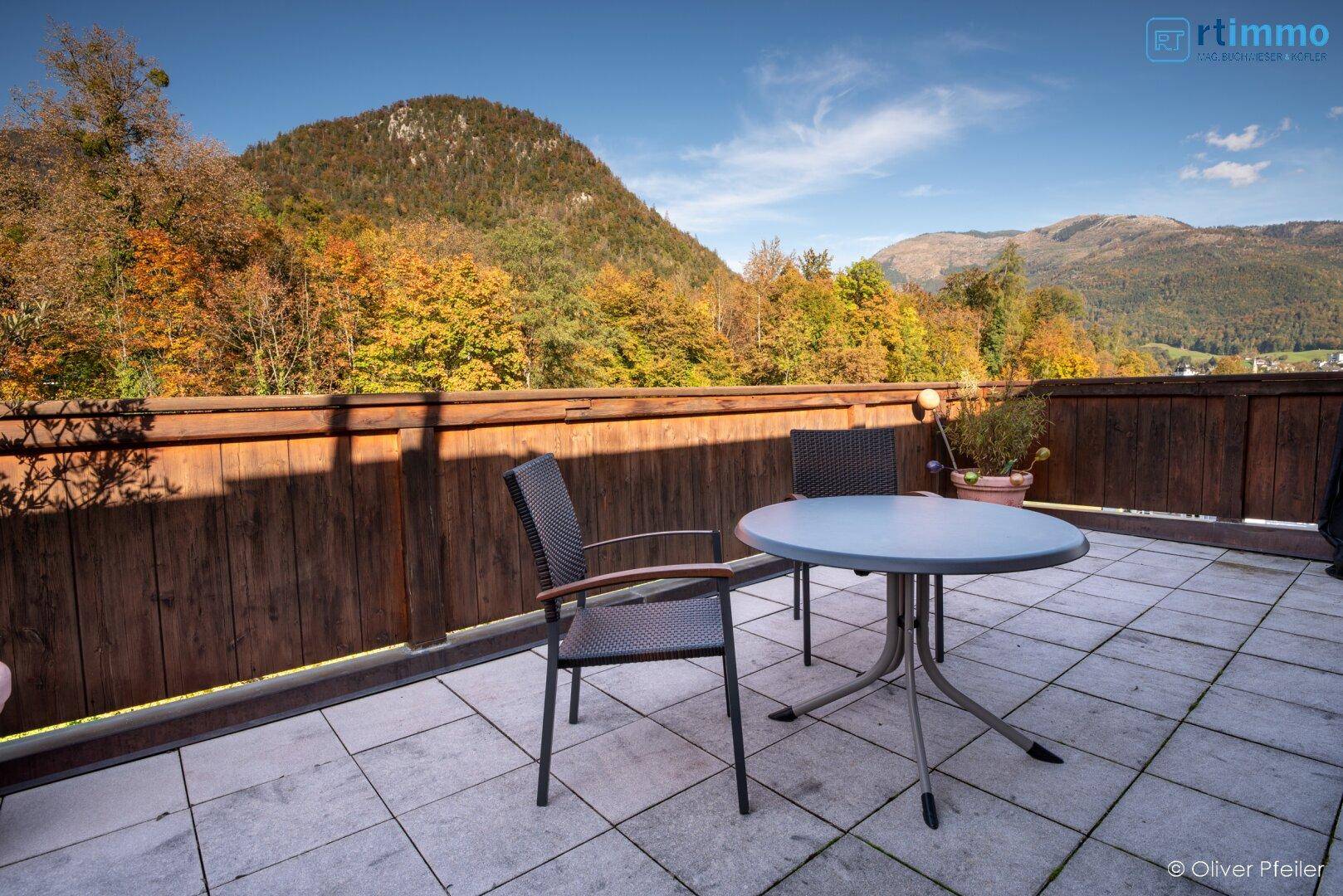 Geräumige Terrasse mit Fliesenboden, Sitzgelegenheiten und Bergblick.