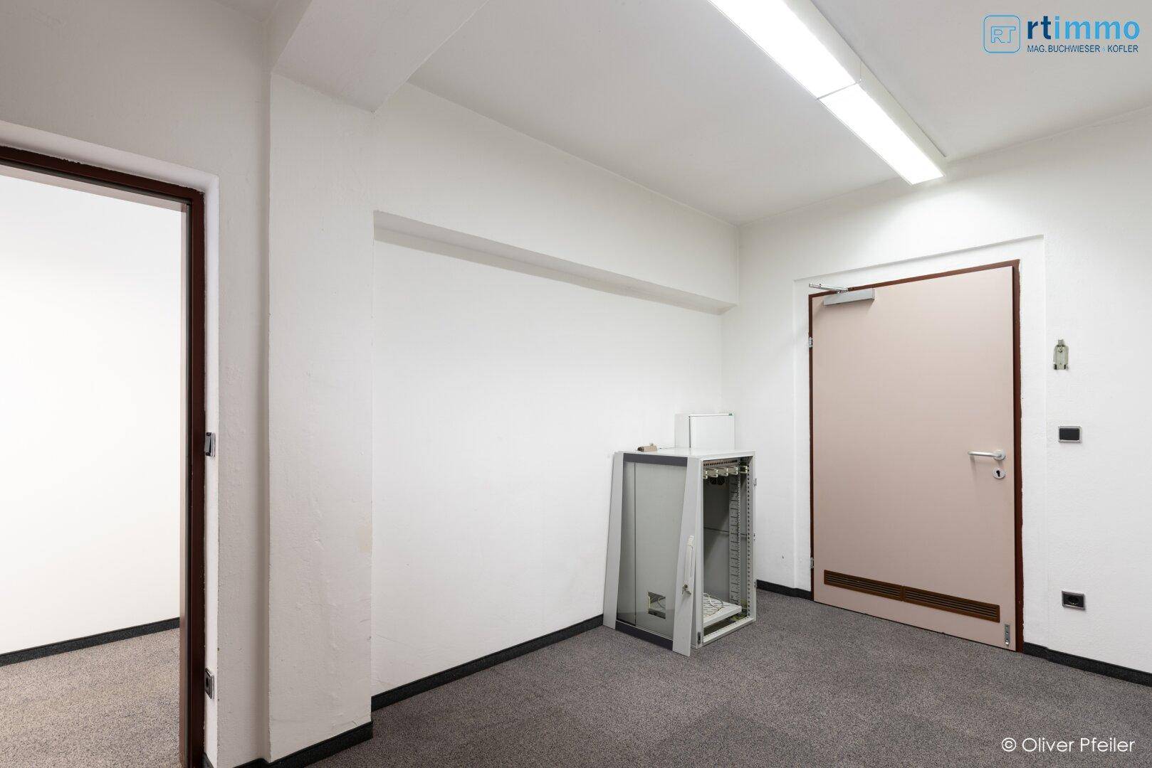 Kleiner Raum mit Teppichboden und einem Verteilerschrank, ideal für Technik.