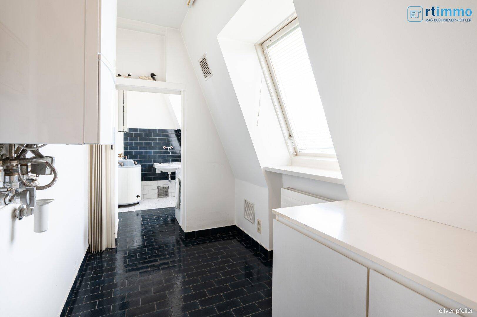 Hauswirtschaftsraum mit Boiler und Blick in einen weiteren Funktionsraum.