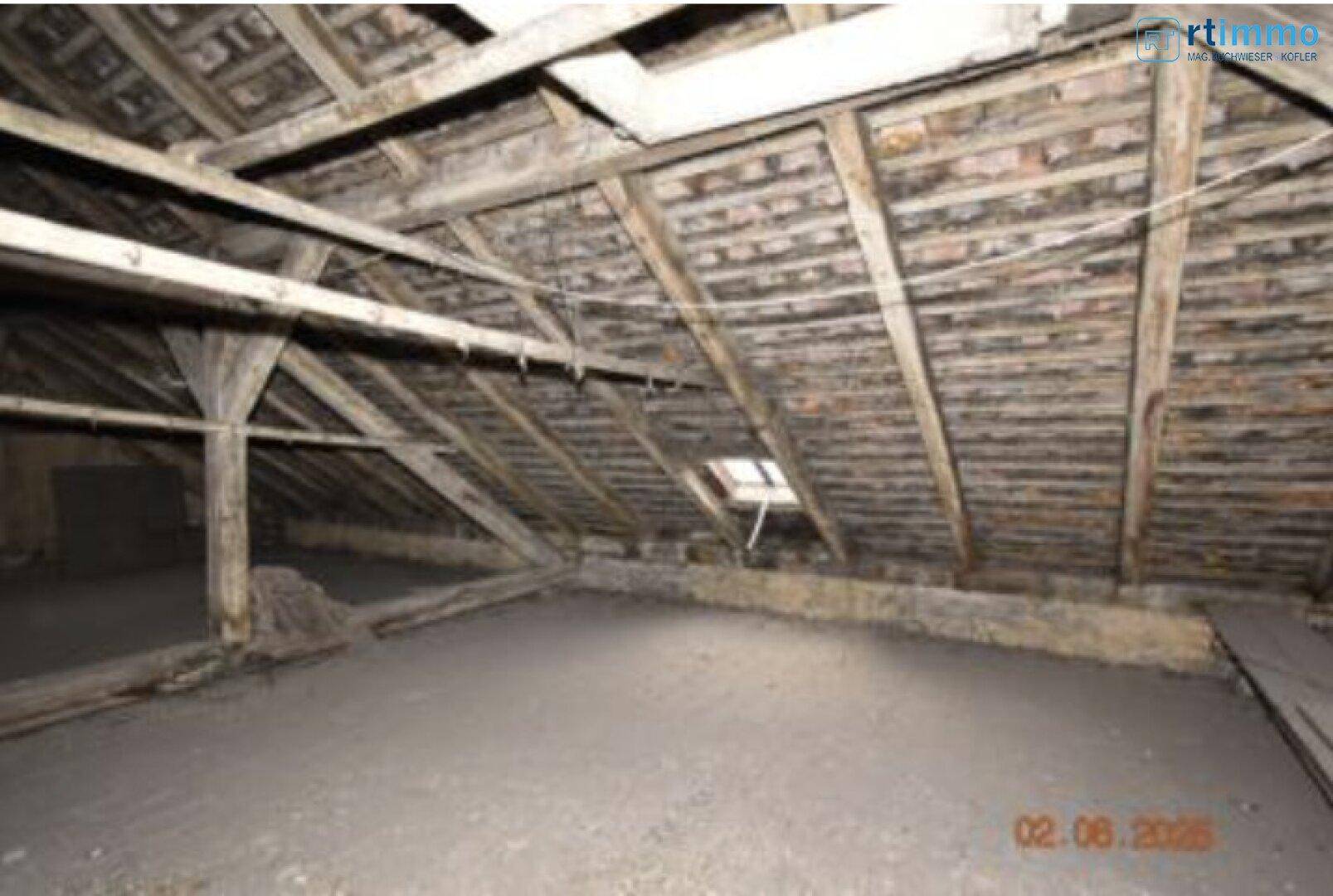 Unausgebauter Dachboden mit sichtbarer Holzkonstruktion und Dachschrägen, bereit für den Ausbau.